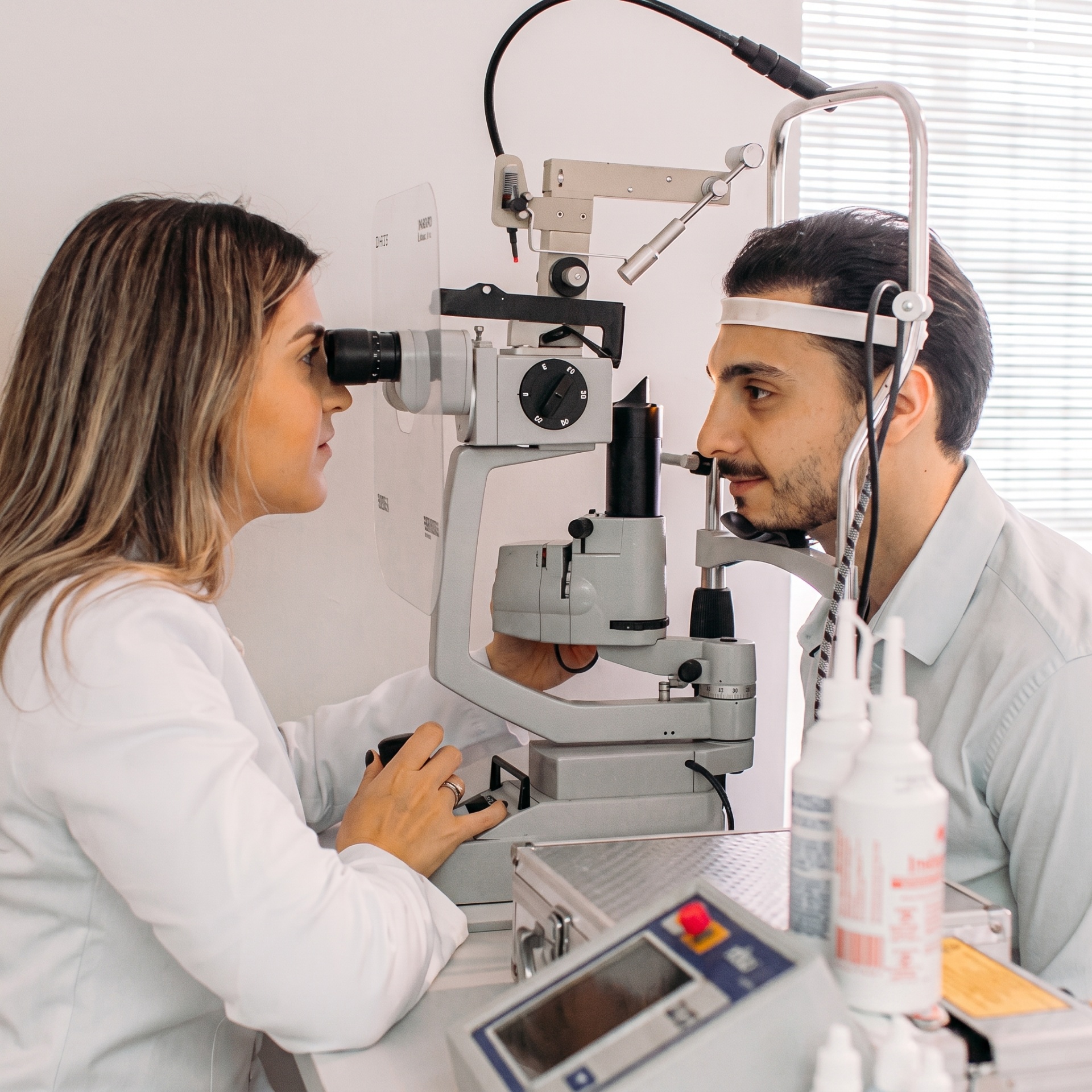 Oftalmologista realizando exame com lâmpada de fenda
